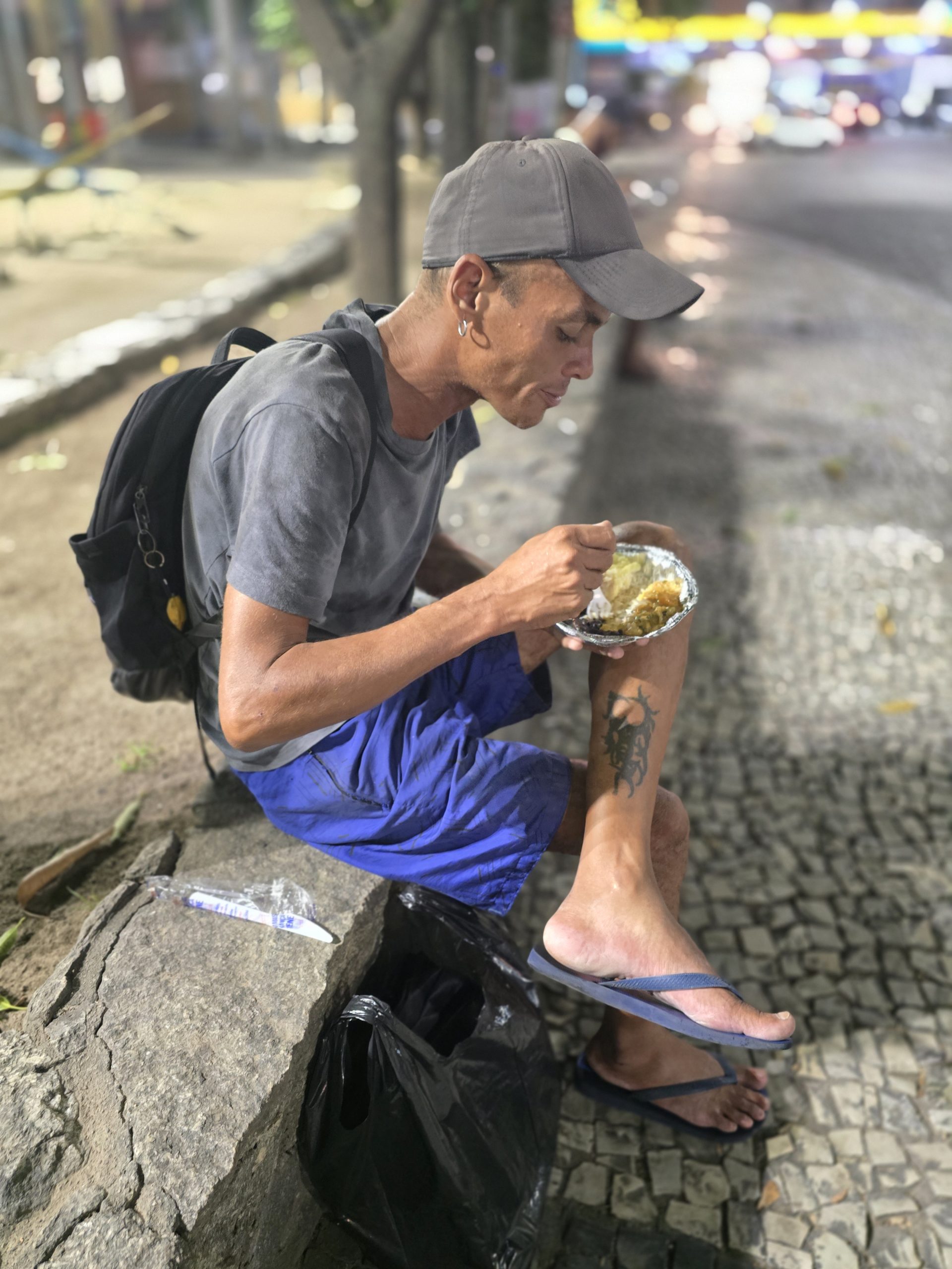 Persona recibiendo una comida en una acción social de la ONG É Por Amor