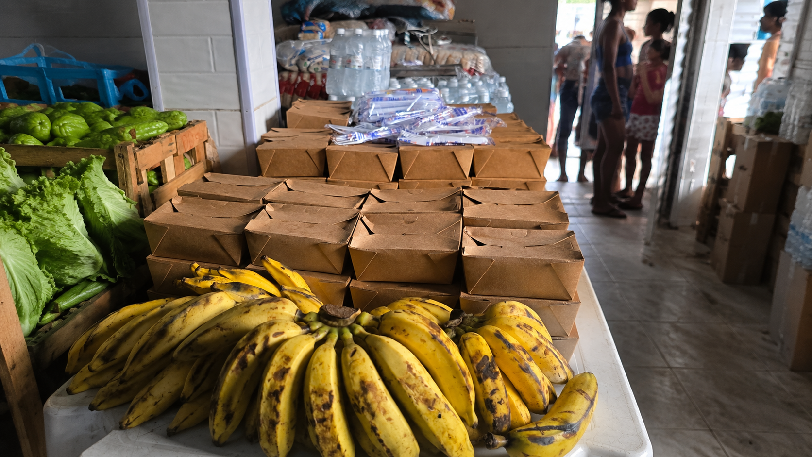 Comidas preparadas, frutas e insumos organizados para acción alimentaria de la ONG É Por Amor